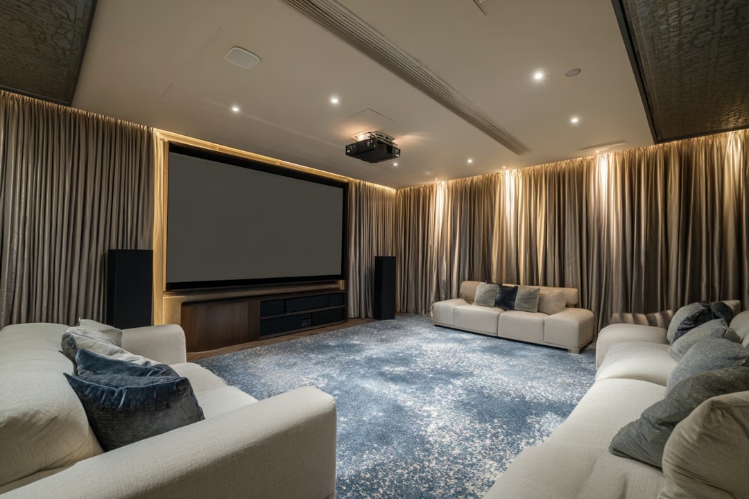 Basement Remodeling in Chicago 15 Basement movie room featuring plush seating, a large projection screen, and ambient lighting, designed for comfort and entertainment.